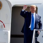 President Donald Trump waves as he steps off Air Force One at John Wayne Airport^ Santa Ana^ Calif.^ on Sunday Oct. 18^ 2020.