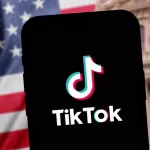 TikTok Logo on phone - sharp in the foreground^ while American Congress building and US flag is blurred in the background^ Concept of TikTok ban in US.