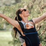 little-baby-girl-and-her-mother-walking-outside-babywearing-in-t