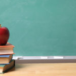 apple-on-school-books-with-copy-space-on-chalk-board