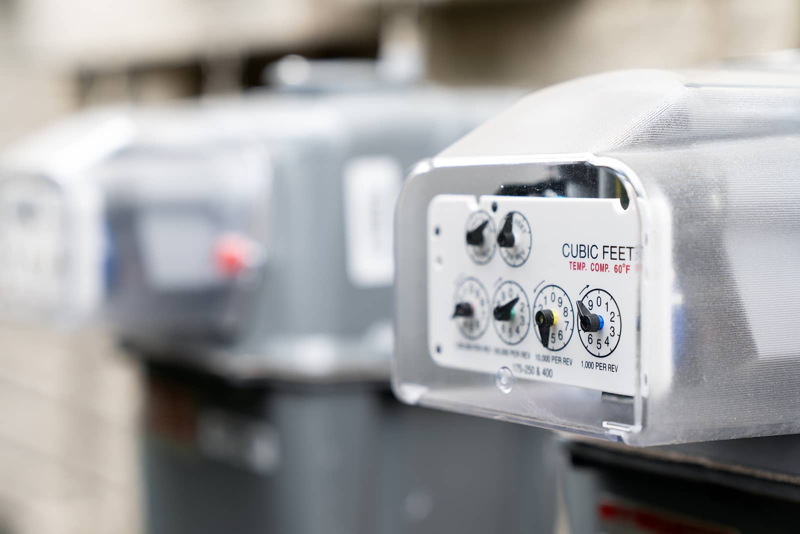 row-of-gray-natural-gas-meters-at-an-apartment-complex