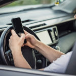 young-driver-guy-distracted-by-his-phone-while-in-front-of-the-s