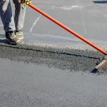 construction-workers-laying-new-asphalt-roads-in-middle-of-proce