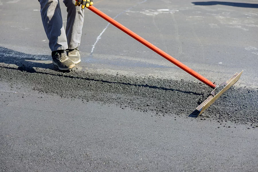 construction-workers-laying-new-asphalt-roads-in-middle-of-proce