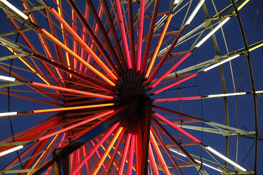 close-up-of-ferris-wheel-at-night-with-neon-light-spokes