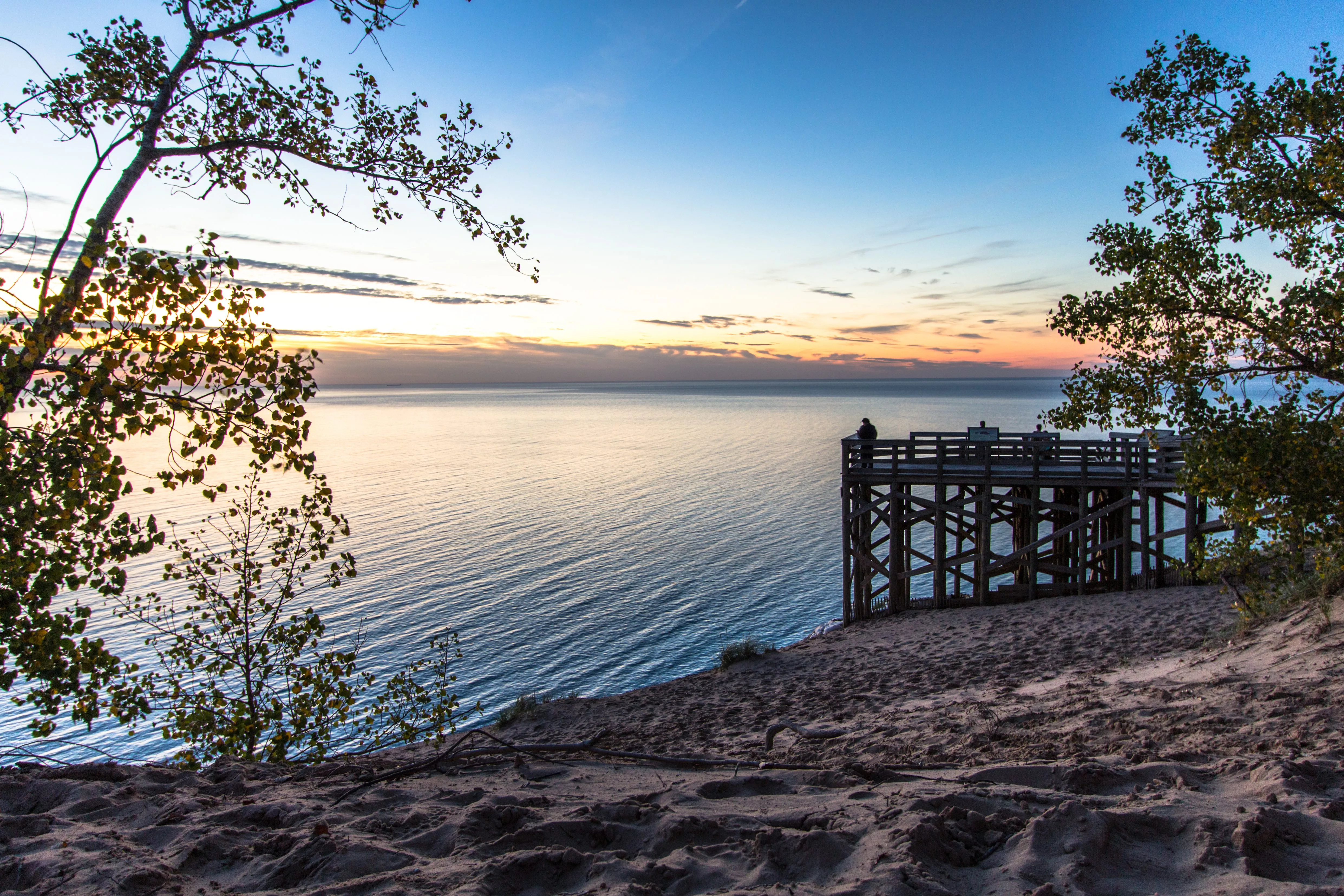 sleeping-bear-dunes-national-lakeshore-large-wooden-overlook-at-sunset-with-silhouette-of-tourist-admiring-the-sunset-at-the-famous-sleeping-bear-dunes-national-park-in-michigan