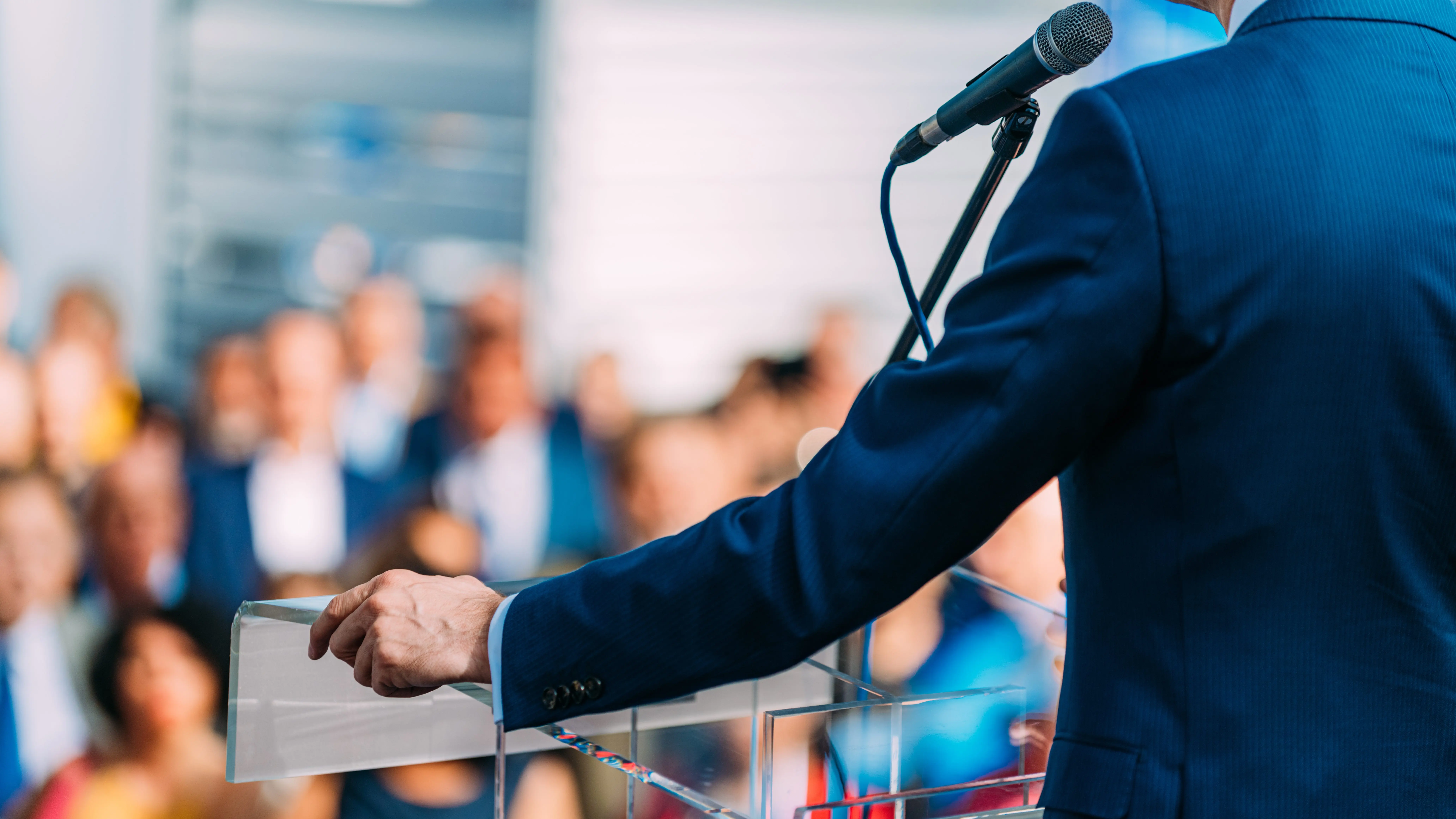 male-speaker-standing-in-front-of-microphones