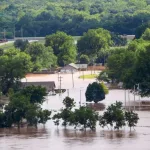 View from 412 Highway to the West of Tulsa Oklahoma as Arkansas river rises and innodates residential area with houses flooded and cars parked in water and a RV tipping over Sand Springs USA 5-25-2019