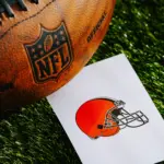 Cleveland Browns NFL team Logo and American football ball on Green Grass.
