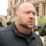 Alex Jones^ flanked by bodyguards^ leaves a rally protesting Covid-19 stay at home orders at the Capitol that was heavily promoted by his Infowars website. Austin^ Tx/USA - Apr. 18^ 2020