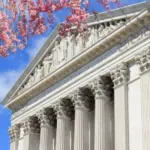 Washington D.C. US Supreme Court building. during spring time; cherry blossoms seen in front of image of Supreme Court