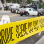 crime or accident scene sign do not pass the line with police cars in the background