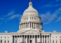 Washington DC Capitol Building facade under blue sky with clouds