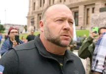 Alex Jones^ flanked by bodyguards^ leaves a rally protesting Covid-19 stay at home orders at the Capitol that was heavily promoted by his Infowars website. Austin^ Tx/USA - Apr. 18^ 2020