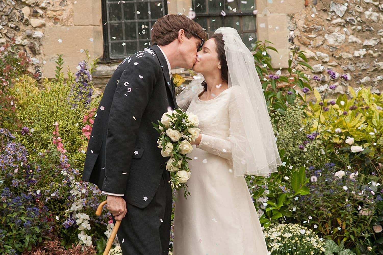Eddie Redmayne and Felicity Jones portray Stephen Hawking and Jane Wilde on their wedding day. As they leave the church, they share a quick kiss.