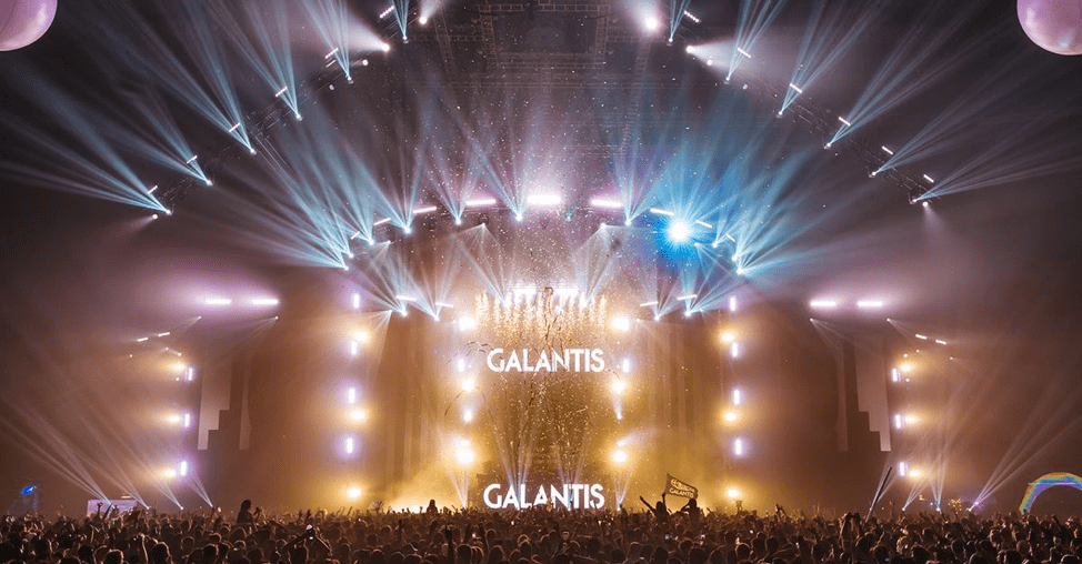 Thousands of audience members throw their hands up and dance to the music. Galantis is on stage, glitter is flying, lights are shining.