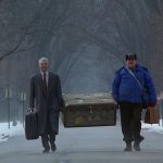 ( Neal (Steve Martin), left, Del (John Candy), right, are finally reaching Chicago, they are smiling and both carry a large trunk)