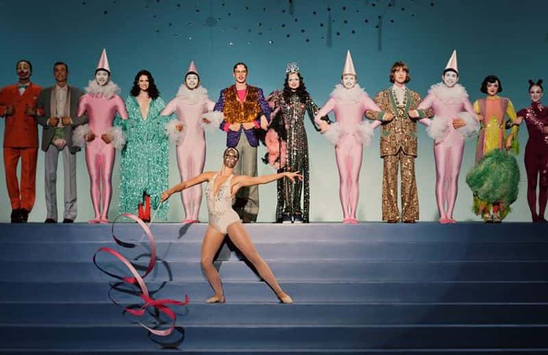 Gucci Showtime: The Spring Summer 2019 Campaign still of performers, showcasing the Spring Gucci line, with linked as if to bow after a performance. There is a performer front, center waving a ribbon.