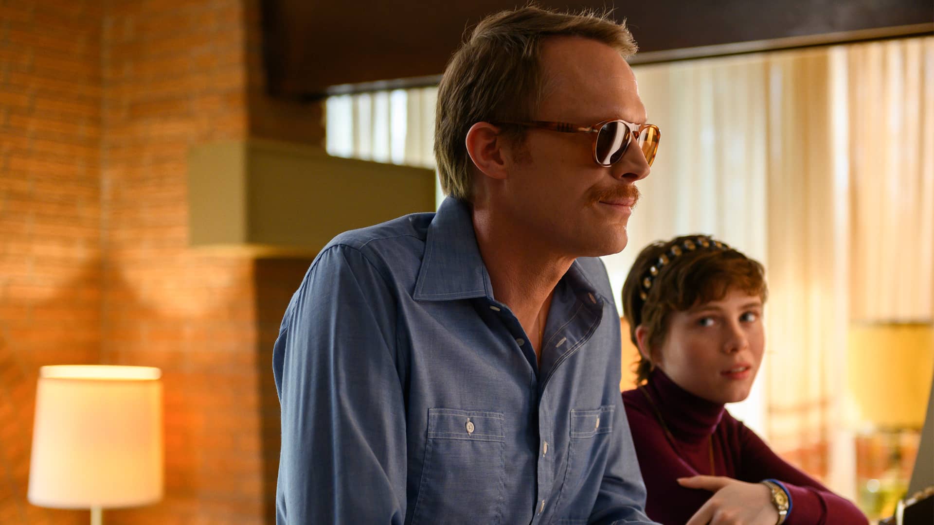 Paul Bettany and Sophia Lillis stand in a motel lobby in the film "Uncle Frank"