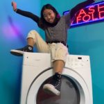 photo of Annie Hoang sitting on a washing machine