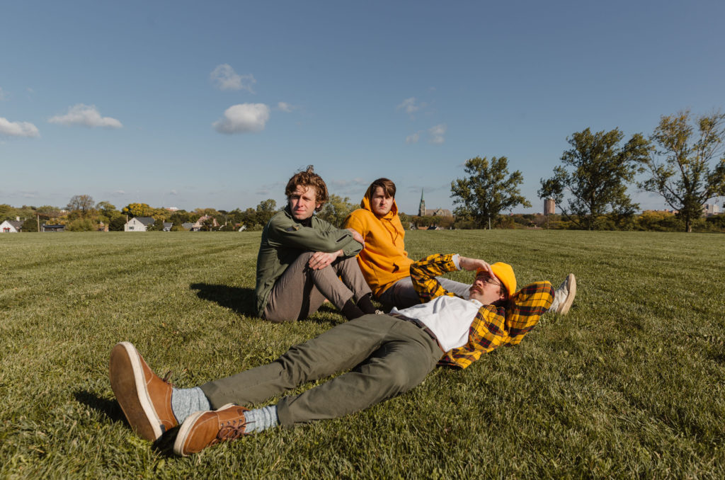 Band members of Diet Lite hanging out outside at a park