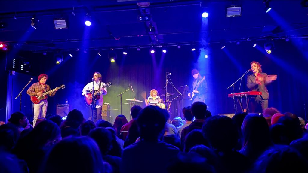 Band Current Joys plays live on stage with blue lights in the background