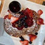 pancakes with powdered sugar and fruits on top