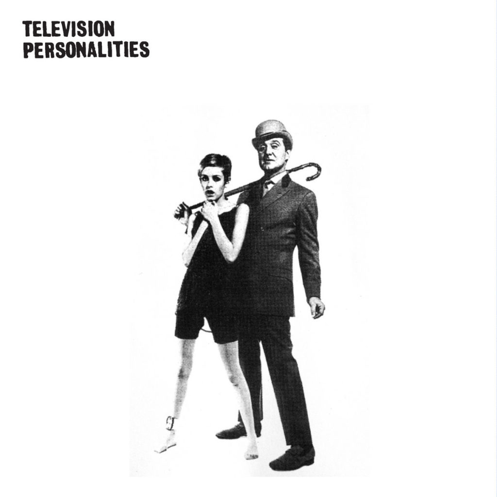 Alt text: The album cover for Television Personalities’ debut studio album, . . . And Don’t The Kids Just Love It (1981). The album cover features a photograph of model, actress, and singer Twiggy with actor Patrick Macnee holding a cane over his shoulder. The name of the band, Television Personalities, is in the top left corner.
