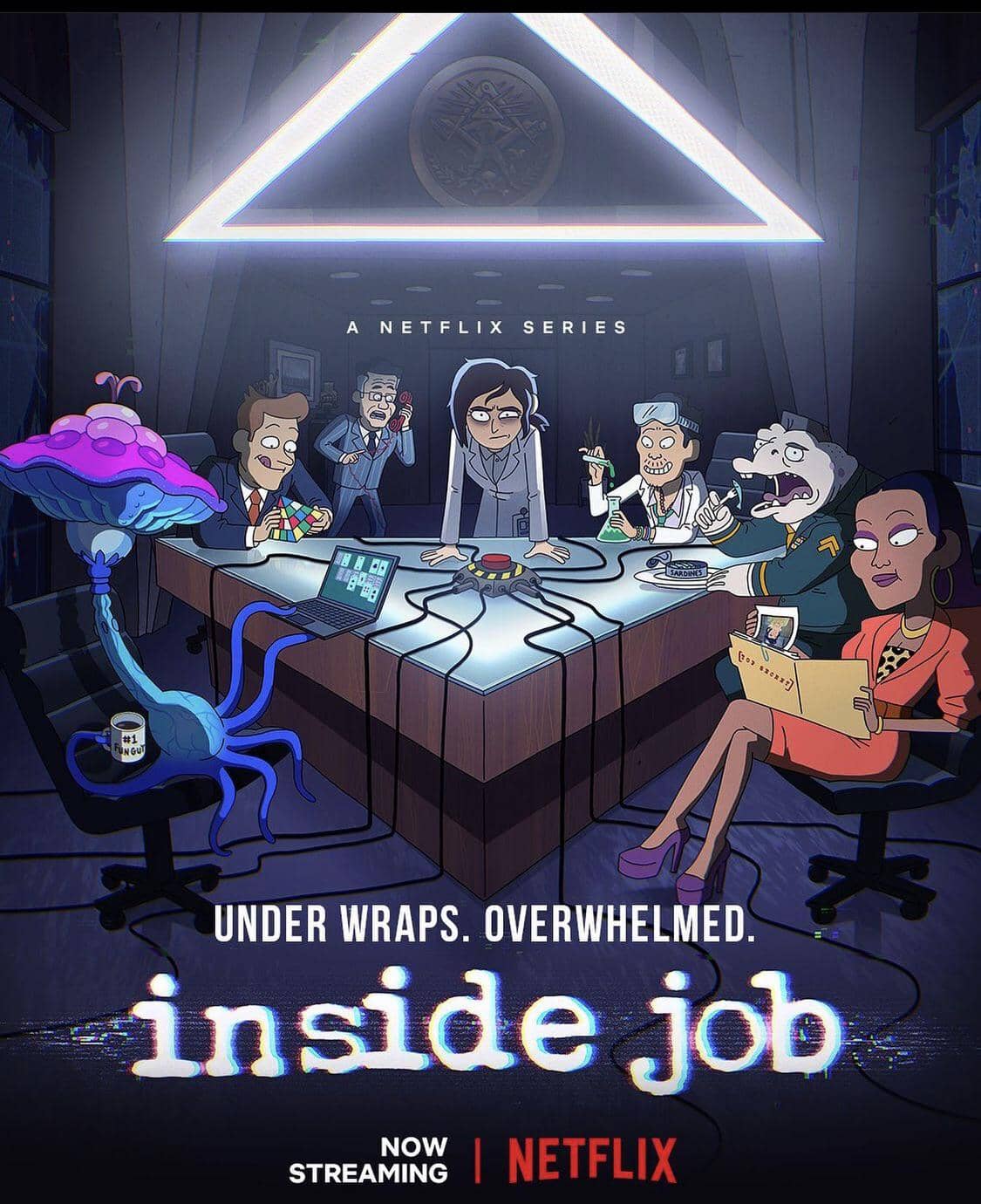 A cartoon of six people sitting around a triangle-shaped table with a red, doomsday button in the middle and wires connected to it. The group consists of a magenta and blue mushroom-shaped alien using a computer, a blonde man in a suit playing with a rubix cube, a tired woman in a lab coat, an asian man mixing chemicals with goodles and a lab coat, a dolphin-man hybrid in a general uniform, and a black woman in a pants suit looking through a file. In the back, an older man in a suit is panicking on the phone. 