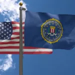 FBI Flag together with American Flag^ USA^ Close-up Frontal on a Pole with blue cloudy sky^ 3D Render