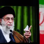 This image captures Iranian Supreme Leader Ali Khamenei giving a speech^ with the Iranian flag prominently displayed.