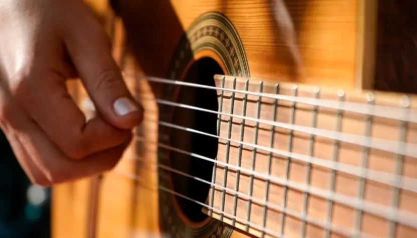 A woman plays an acoustic guitar.