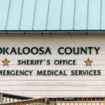 Okaloosa Island county Sheriff's Office emergency medical services building with sign by beach by ramp in Florida Panhandle^ Gulf of Mexico