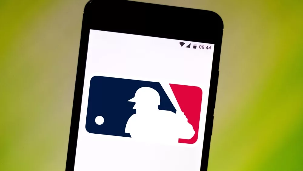 Major League Baseball Logo (MLG) is displayed on a smartphone with a green background