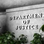 Silver sign of Department of Justice on a classical concrete wall with plants as foreground. 3D illustration of the concept of enforcement of federal laws
