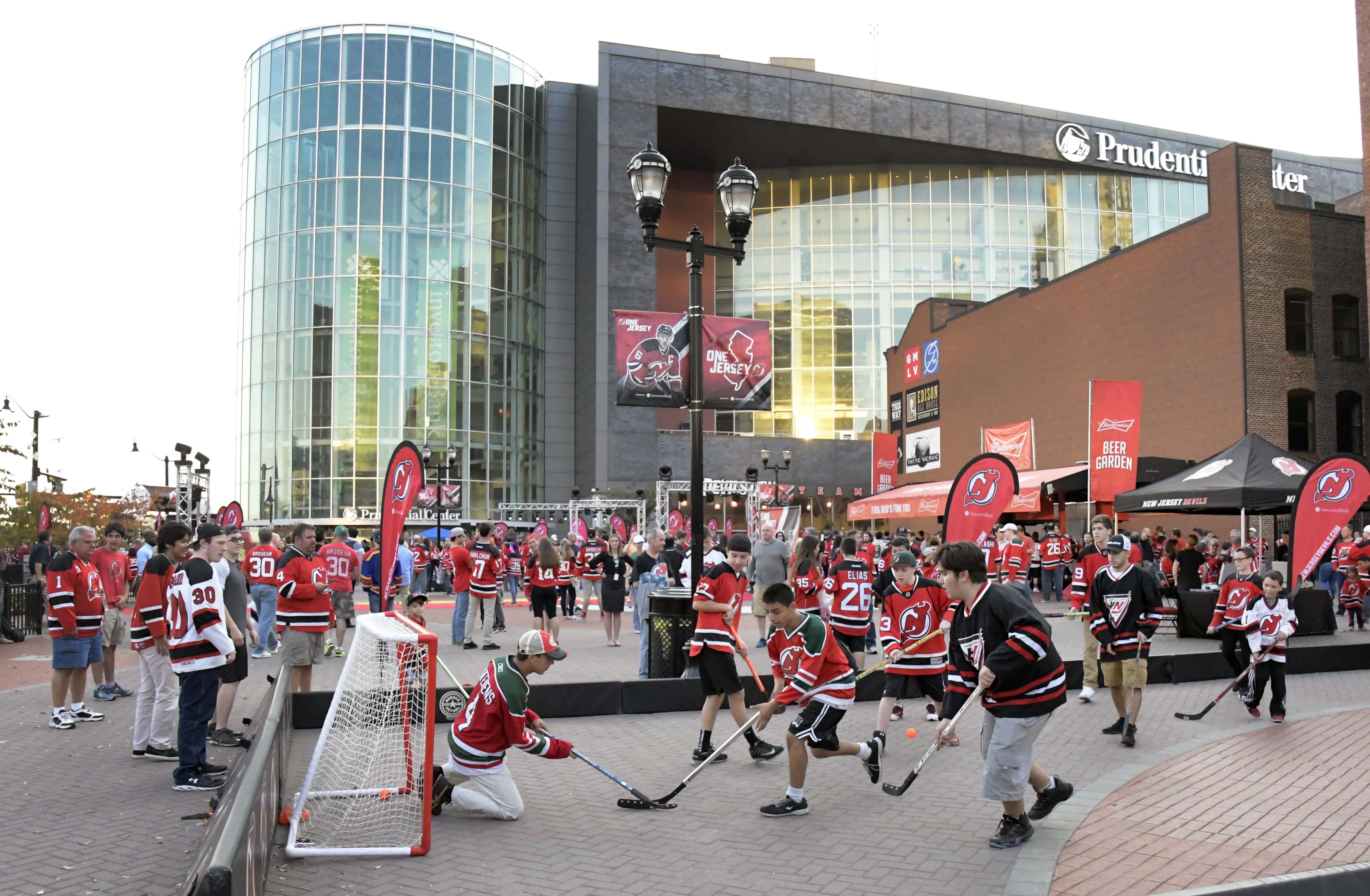Fans play street hockey outside the Prudential Center before the New Jersey Devils' NHL hockey home-opener against the Anaheim Ducks, Tuesday, Oct. 18, 2016, in Newark, N.J. (AP Photo/Bill Kostroun)