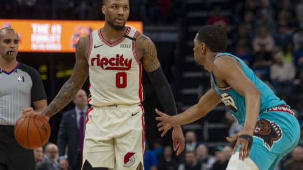 Feb 12, 2020; Memphis, Tennessee, USA; Portland Trail Blazers guard Damian Lillard (0) handles the ball against Memphis Grizzlies guard De'Anthony Melton (0) during the first half at FedExForum. Mandatory Credit: Justin Ford-USA TODAY Sports