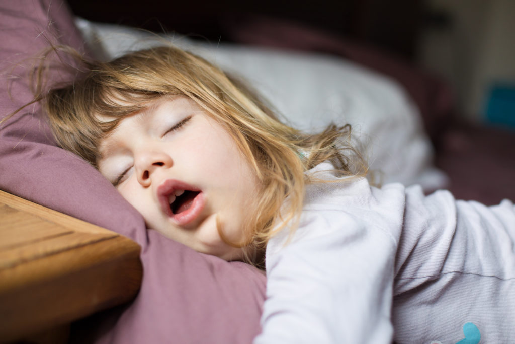 funny-face-of-child-sleeping-on-king-bed