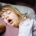 funny-face-of-child-sleeping-on-king-bed