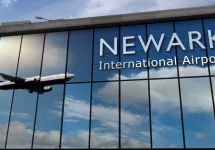 Aircraft landing at Newark^ New Jersey^ USA 3D rendering illustration. Arrival in the city with the glass airport terminal and reflection of jet plane. Travel^ business^ tourism and transport.