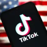 TikTok logo is seen displayed on a smartphone screen and in the background^ the United States flag^ in Reno^ United States^ on January 15^ 2025 In this photo illustration^ the TikTok logo is seen displayed on a smartphone screen and in the background^ the United States flag^ in Reno^ United States^ on January 15^ 2025