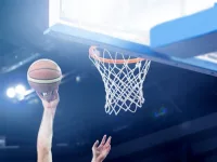 Ball in hoop at basketball game. Athletic competitions and games concept.