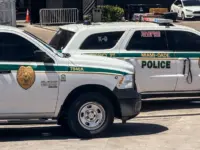 Two Miami-Dade police K-9 cars are parked near a metal security fence on a bright sunny day. Miami^ Florida^ USA^ June 16th 2025
