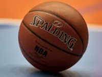 Gdansk^ Poland - 08 02 2024: Close-up of a Spalding NBA basketball resting on a blue and orange court^ focusing on the texture of the ball and the surrounding vibrant colors of the court.