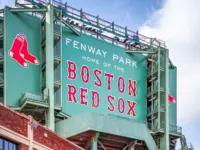 Vew of the historic architecture of the Famous Fenway Park Stadium in Boston^ MA^ USA showcasing its huge sign^ old brick walls^ and entrances on Lansdowne street. Boston^ MA^ USA - March 1^ 2023