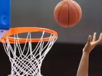 Orange basketball ball flying into the basketball hoop