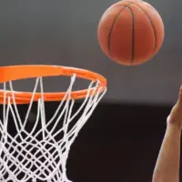 Orange basketball ball flying into the basketball hoop
