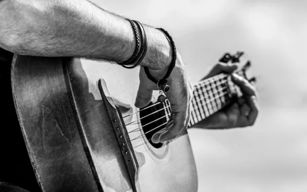 Acoustic guitars playing. Music concept. Black and white. Male musician playing guitar^ music instrument. Man's hands playing acoustic guitar^ close up.