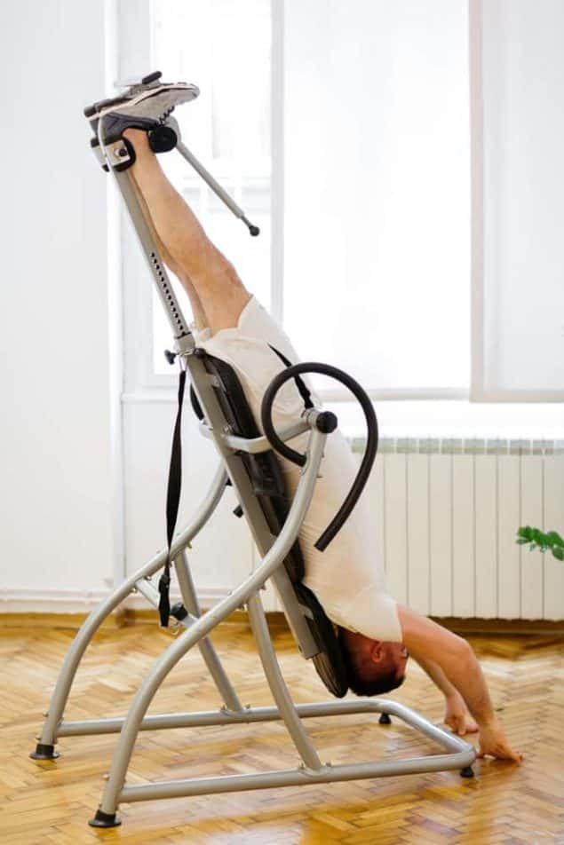 man upside down on inversion table