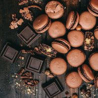 chocolate and chocolate macaroons scattered on table